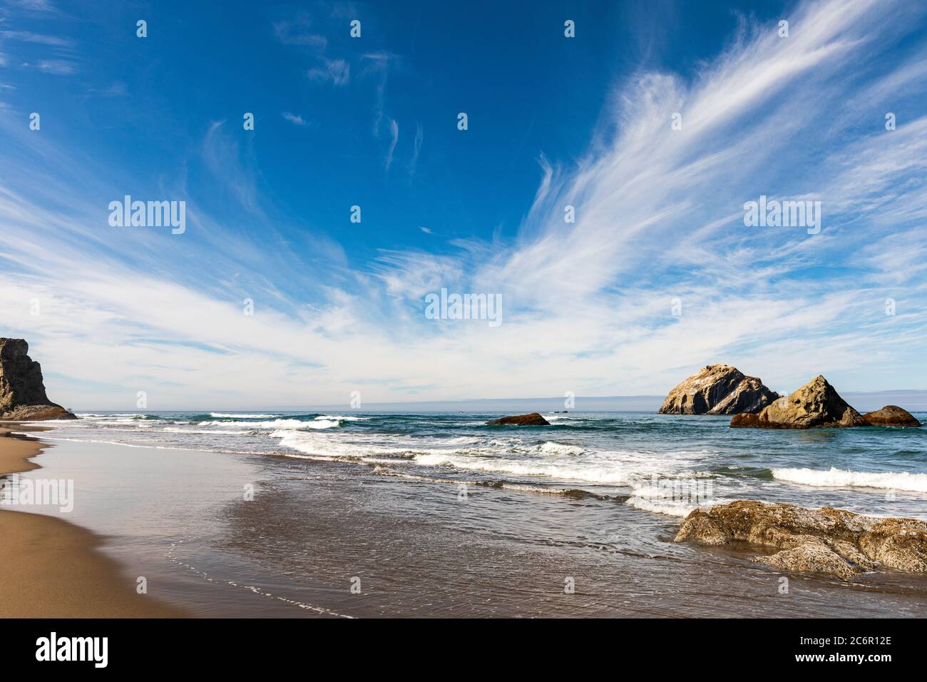 Cielo blu con alte nuvole sopra le pile di mare sulla spiaggia di Bandon in Oregon Foto Stock