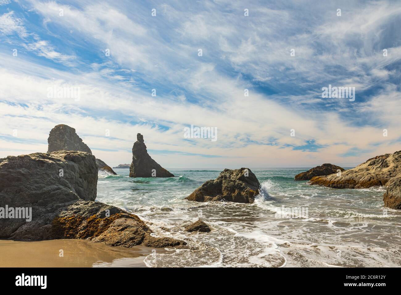 Ampi cieli blu sopra le onde che si infrangono sulla spiaggia di Bandon in Oregon Foto Stock