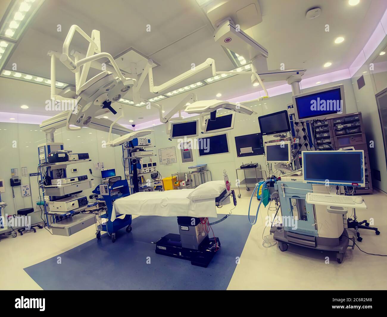 Sala operatoria in un moderno ospedale interno con letto al centro, anestesiologia e attrezzature per l'illuminazione. Nessuna persona Foto Stock