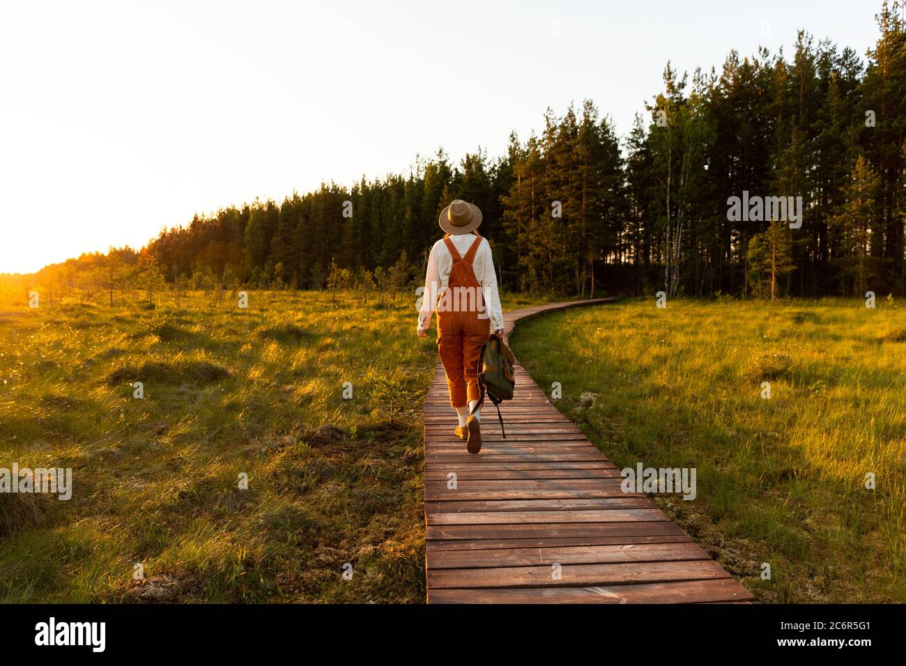 Donna botanica con zaino su sentiero escursionistico ecologico in estate all'aperto. Naturalista esplorare la fauna selvatica e avventura ecoturismo a piedi sul percorso Thr Foto Stock