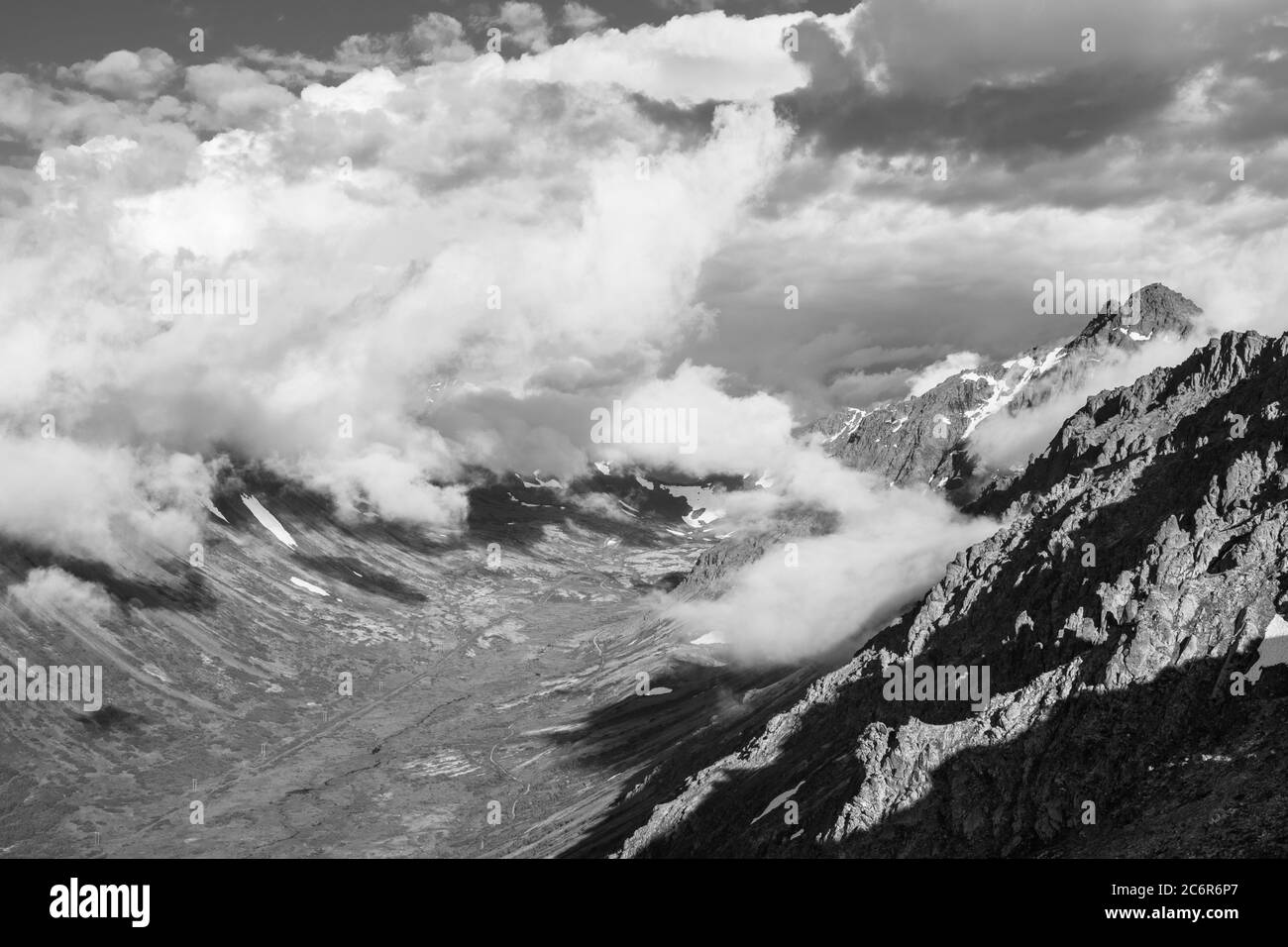 Nuvole che costeggiano la valle e che si schiumano sulle cime Foto Stock