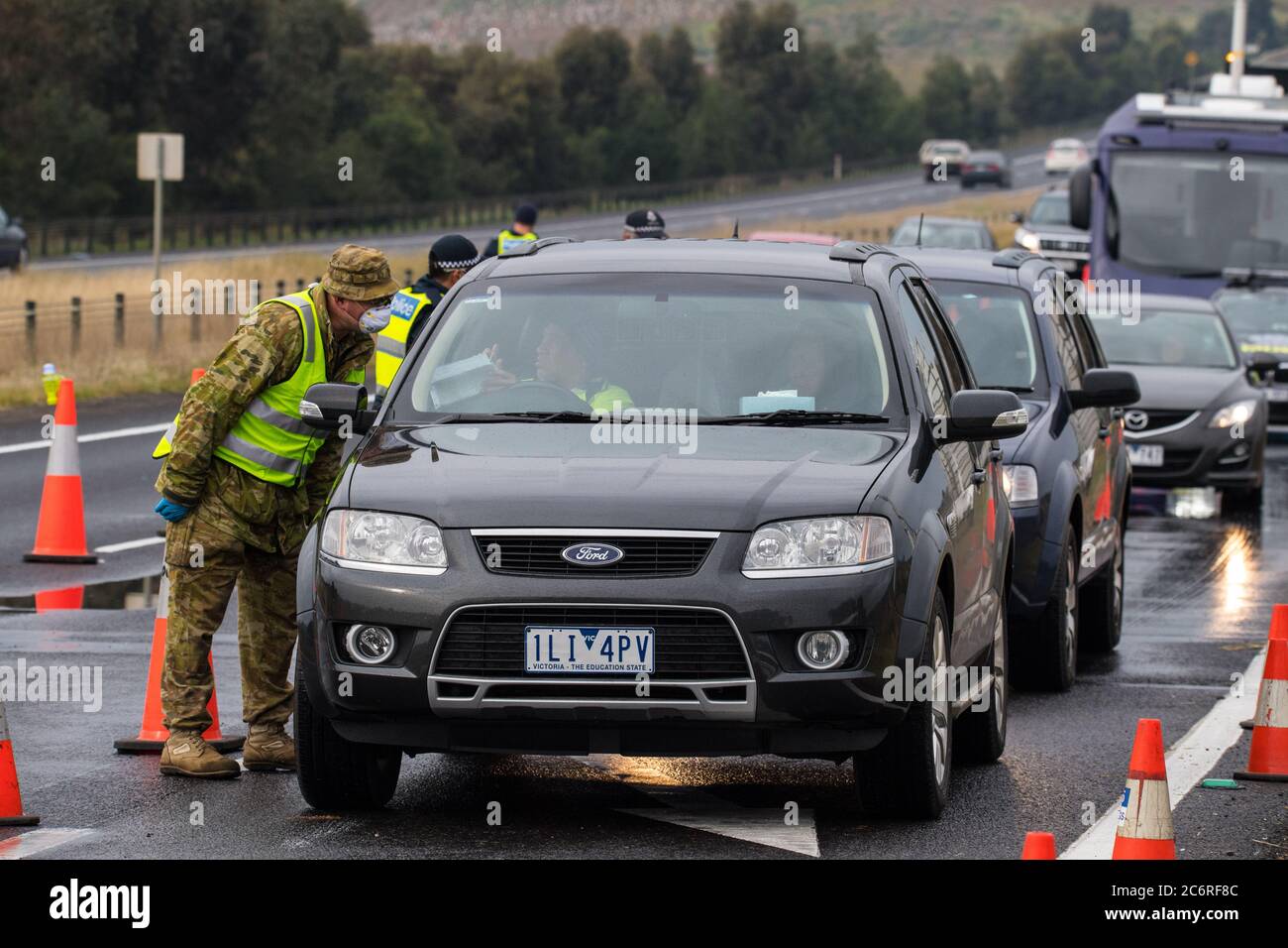 Melbourne, Australia 11 luglio 2020, un soldato australiano controlla i dettagli di un conducente in uno dei blocchi stradali sulla Western Highway di Victoria nel tentativo di contenere la diffusione del virus della corona nel secondo stato più popoloso dell’Australia. Credit: Michael Currie/Alamy Live News Foto Stock