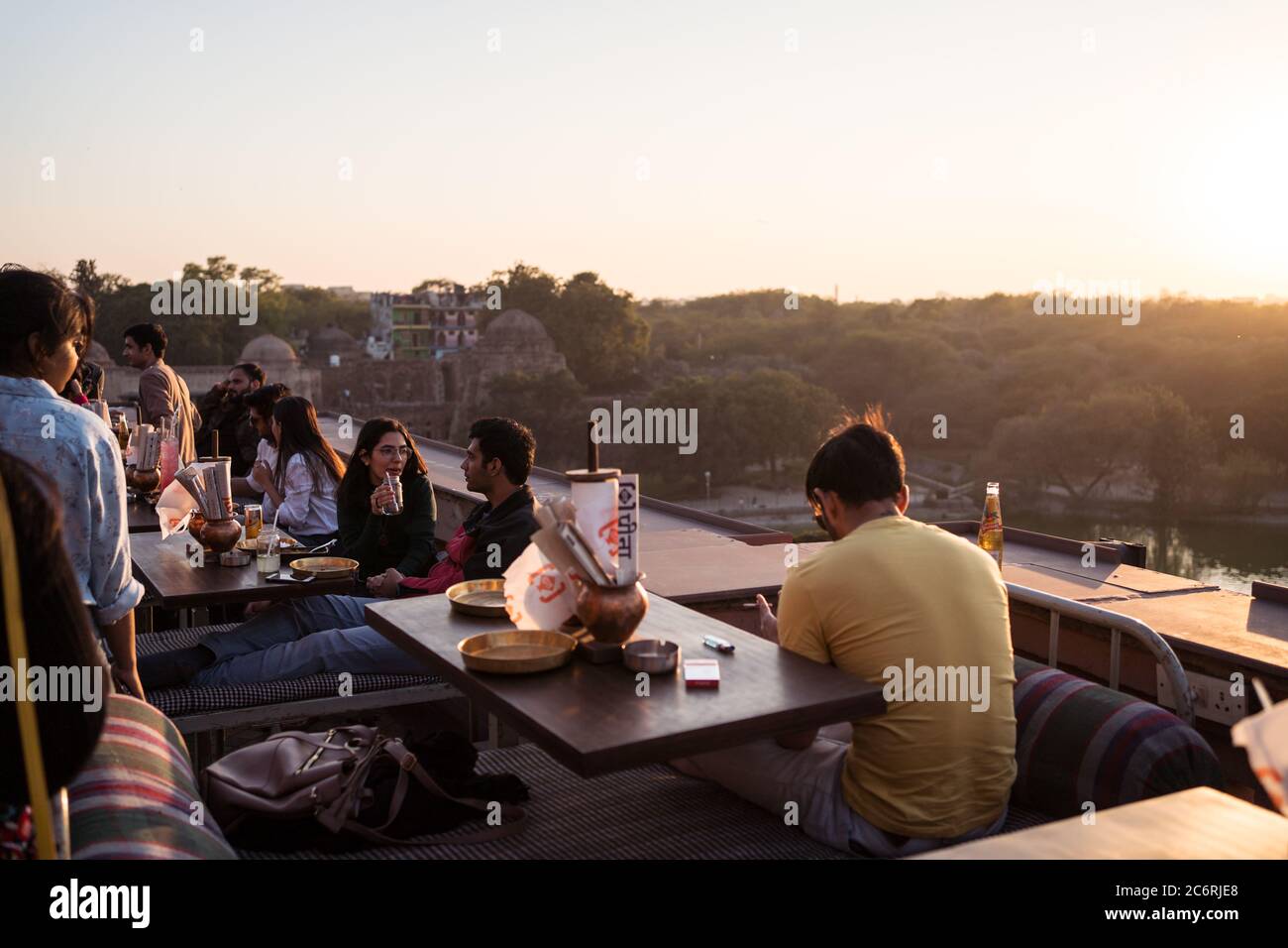 New Delhi / India - 17 febbraio 2020: Giovani indiani locali godendo del tempo libero in un caffè con una splendida vista sul Parco del Distretto di Hauz Khas dal tetto Foto Stock