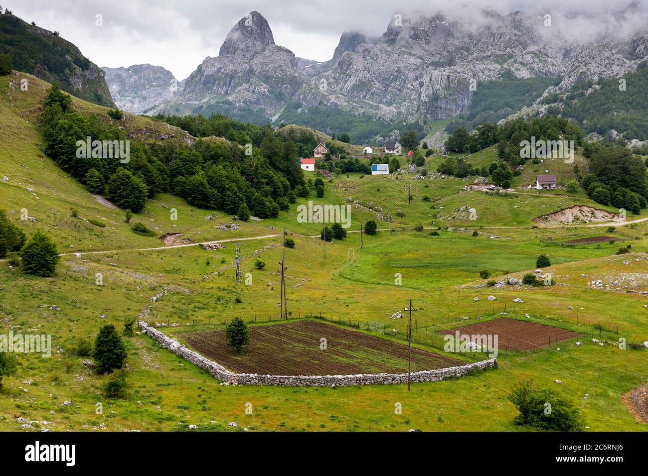 Vista sul prato con pascoli e capanne tradizionali e splendida vista sulle montagne del lago Bukumirsko, Montenegro Foto Stock