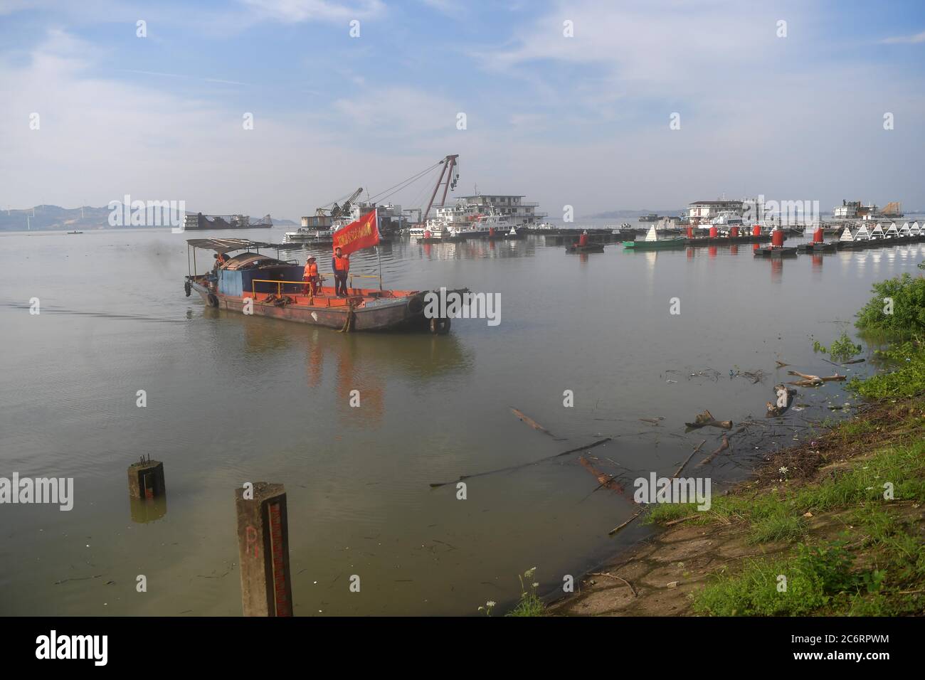 Nanchang. 12 luglio 2020. Il personale si prepara a misurare la velocità del flusso in barca presso la stazione idrologica di Xingzi del lago Poyang nella provincia di Jiangxi, nella Cina orientale, il 12 luglio 2020. Il lago Poyang, il più grande lago d'acqua dolce della Cina, situato nella provincia orientale di Jiangxi, ha visto il suo livello d'acqua salire a un massimo record sabato mezzanotte, secondo il dipartimento provinciale delle risorse idriche. Credit: Peng Zhaozhi/Xinhua/Alamy Live News Foto Stock