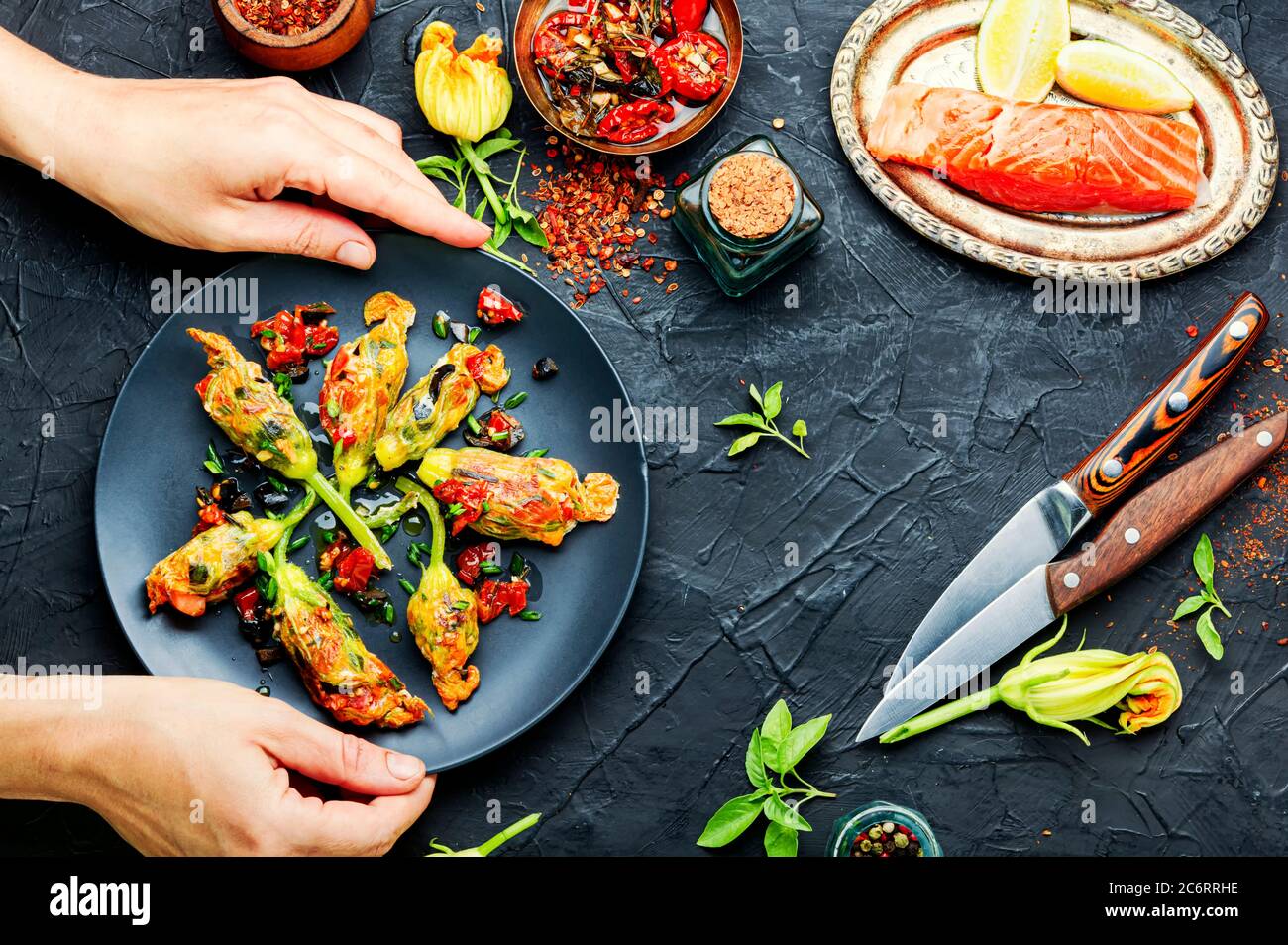 Fiori di zucchine fritti ripieni di salmone e pomodori secchi. Foto Stock