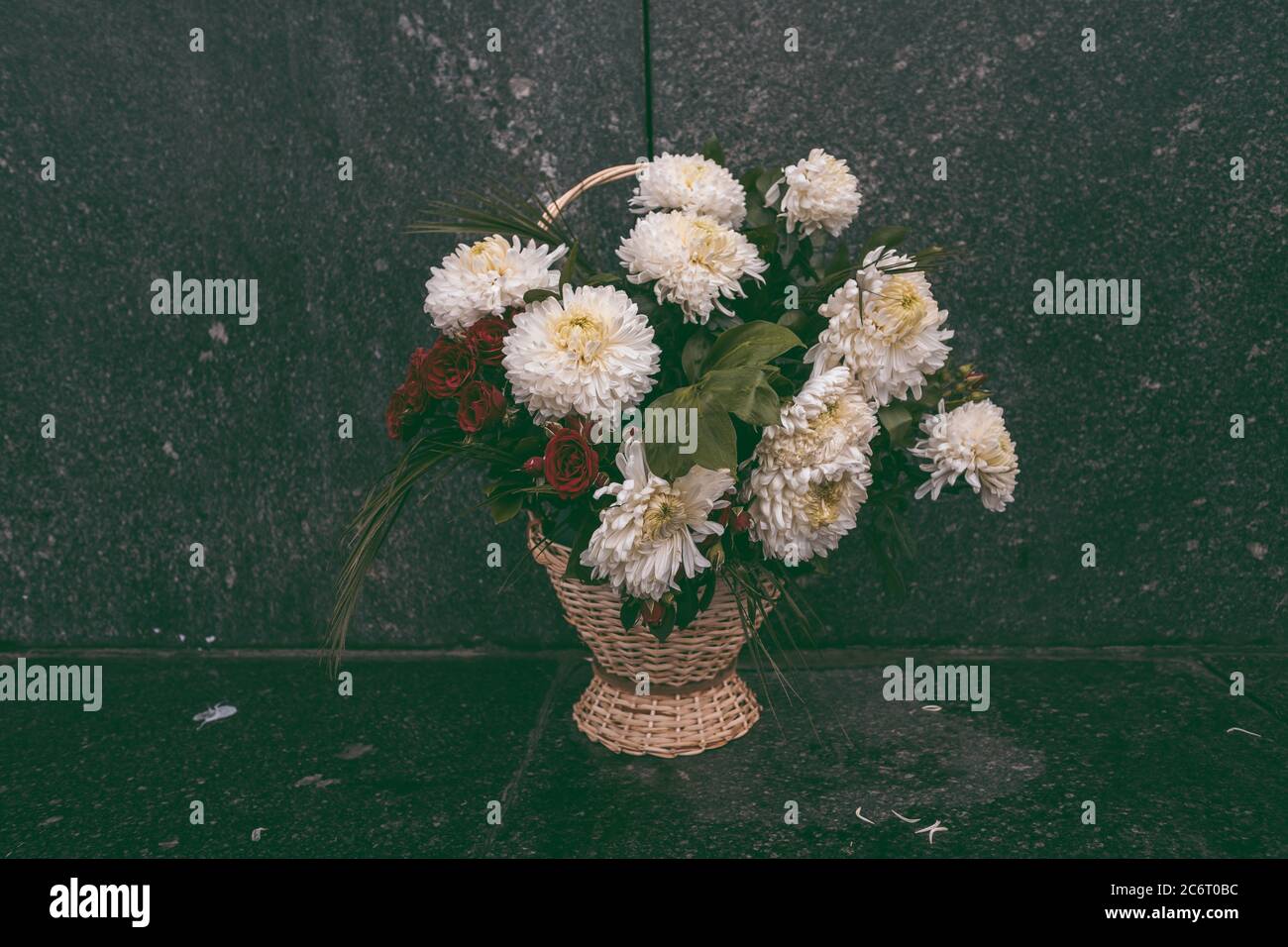 Fiori sui monumenti, un solo bouquet di fiori si trova sulla strada, su uno sfondo nero Foto Stock