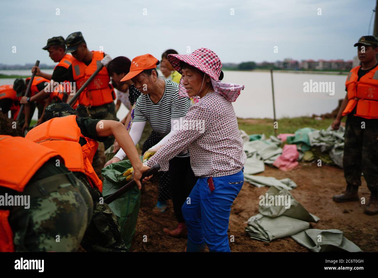 (200712) -- POYANG, 12 luglio 2020 (Xinhua) -- Volontarii confezionano sacchi di sabbia nel Villaggio di Jiangjialing, Poyang Città della Provincia Jiangxi della Cina orientale, 11 luglio 2020. A causa delle forti precipitazioni piovose durature, la Provincia di Jiangxi della Cina orientale ha aumentato la sua risposta al controllo delle inondazioni dal livello III al livello i in soli tre giorni. Oltre ai membri del partito del Partito comunista cinese (CPC) e alla polizia armata che sono organizzati per partecipare alla lotta contro l'alluvione, un gruppo volontario composto da donne anziane nel villaggio di Jiangjialing dedica i loro sforzi. Yu Fengying, team leader del gruppo, ha detto che sono originali Foto Stock