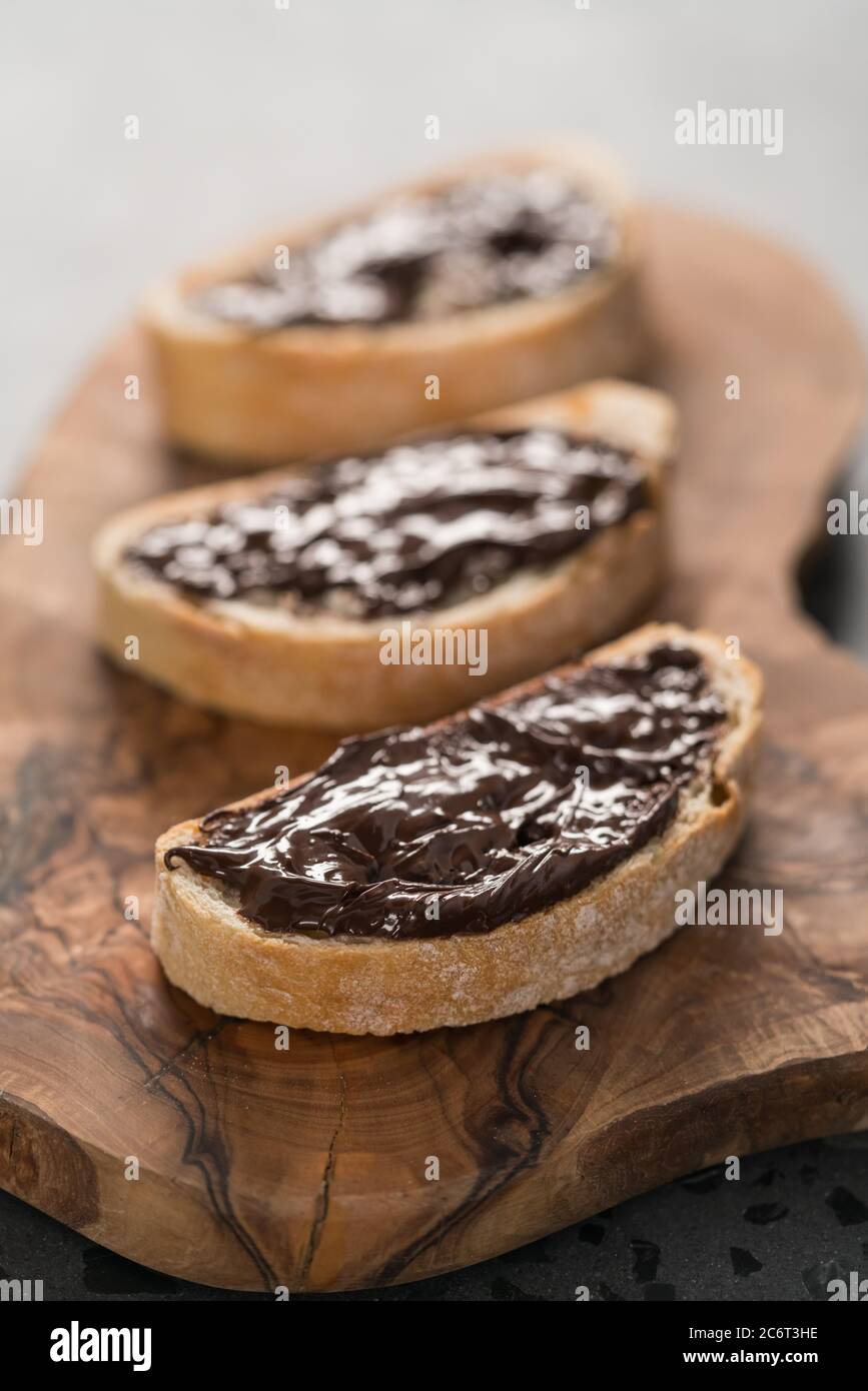 Ciabatta rustica con crema di cioccolato biologica su tavola di ulivo Foto Stock