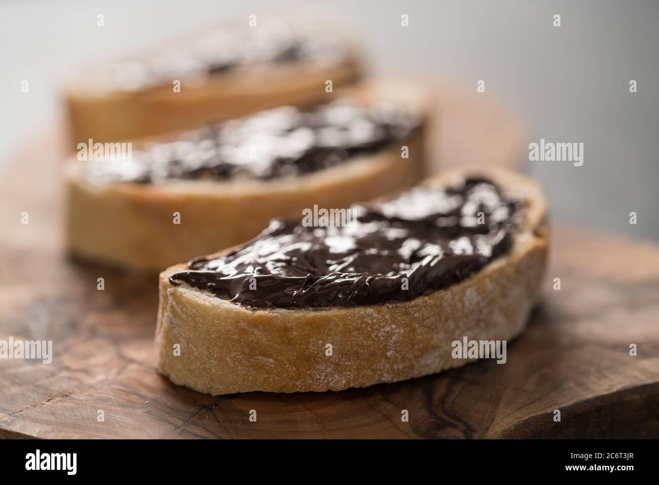 Ciabatta rustica con crema di cioccolato biologica su tavola di ulivo Foto Stock