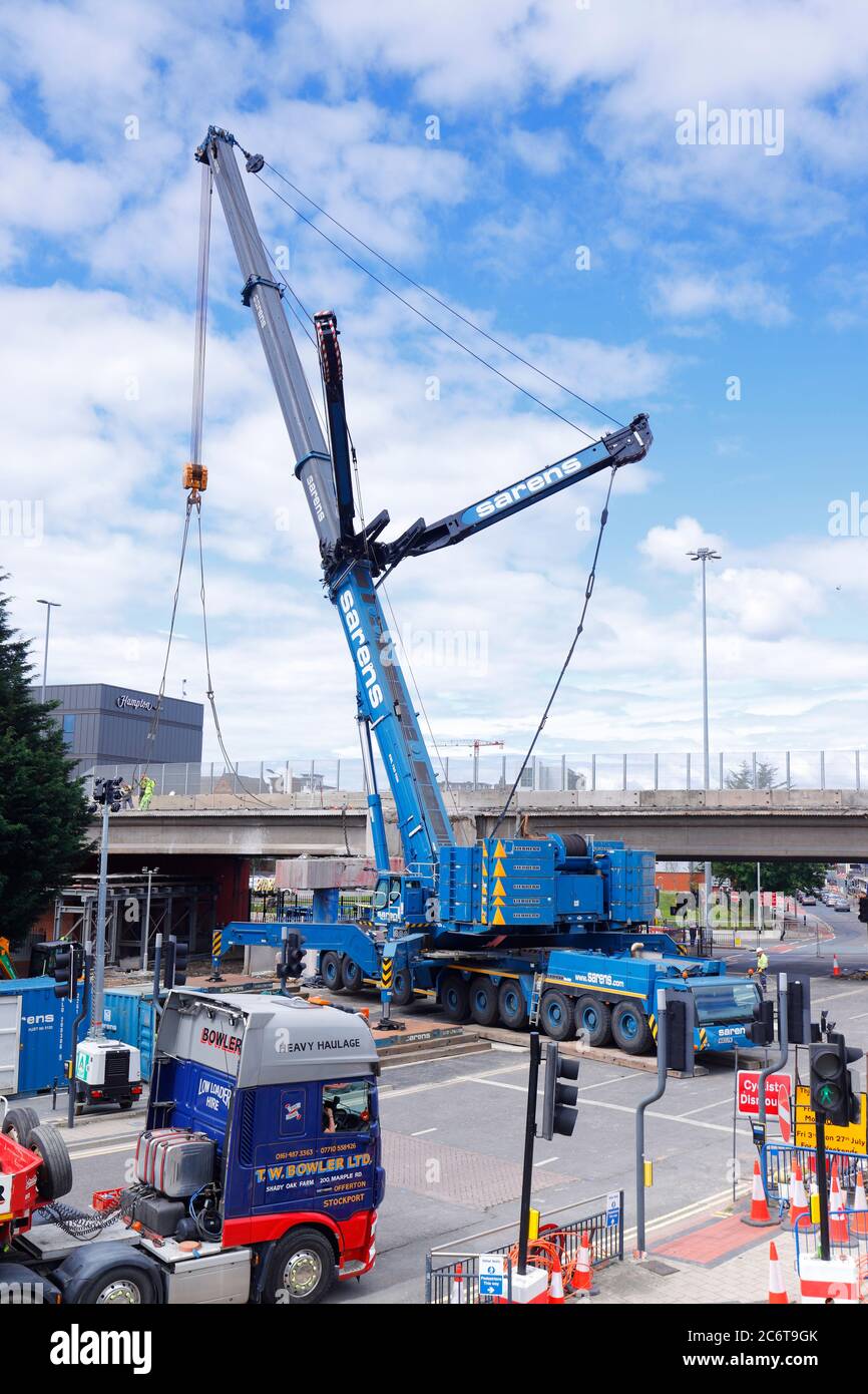 Demolizione di Regent Street Flyover a Leeds. Una gru Liebherr LTM 1750 di Sarens, solleva sezioni di ponte su caricatori bassi. Foto Stock