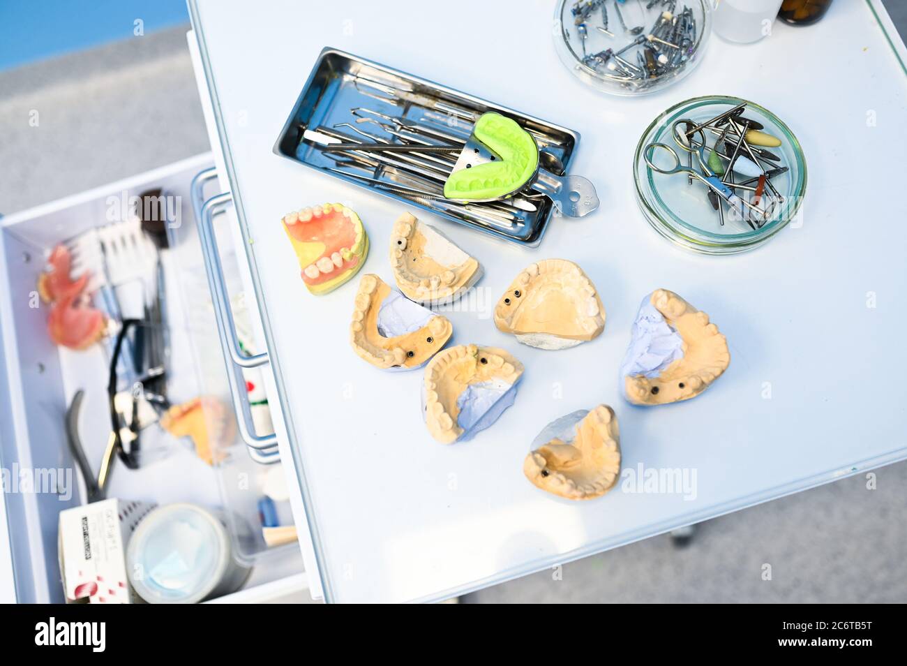 Diversi strumenti, strumenti e attrezzature dentali professionali in una clinica di studio di stomatologia dentista su sfondo bianco. Silicone fuso della ganascia Foto Stock
