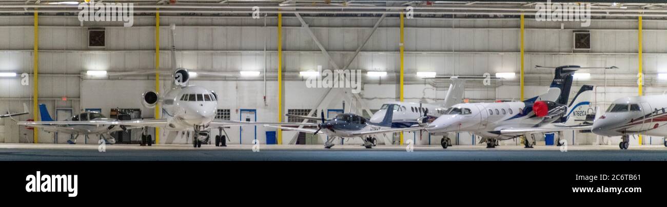 Un assortimento di jet privati parcheggiati in un hangar aereo Foto Stock