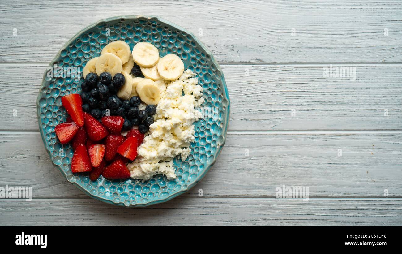 Sana colazione estiva. Formaggio di cottage con fragola mirtillo banana e miele. La colazione era bellissima Foto Stock