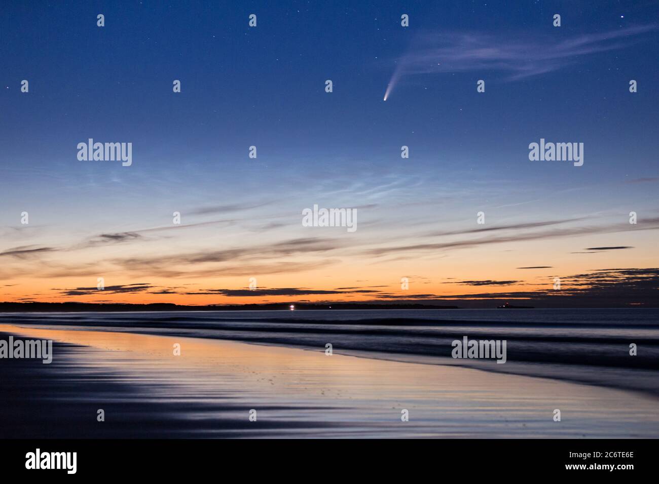 Comet NOEWISE e nube noctilucente sulla spiaggia di Drumidge Bay sulla costa del Northumberland, Inghilterra nord-orientale nel mese di luglio. Foto Stock