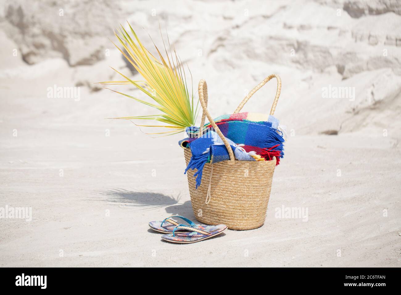 pronto per prendere il sole e per le vacanze. Una borsa con una coperta e infradito sulla spiaggia Foto Stock