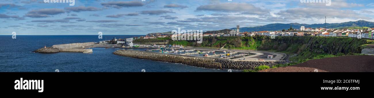 Vista panoramica del molo colorato e del porto di Rabo de Peixe villaggio con barche, chiesa e faro a Sao Miguel, la più grande delle isole Azzorre Foto Stock