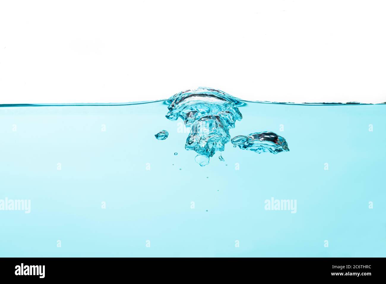 Bolle d'aria e spruzzi d'acqua, acqua spruzzata isolata su sfondo bianco e blu. Foto Stock