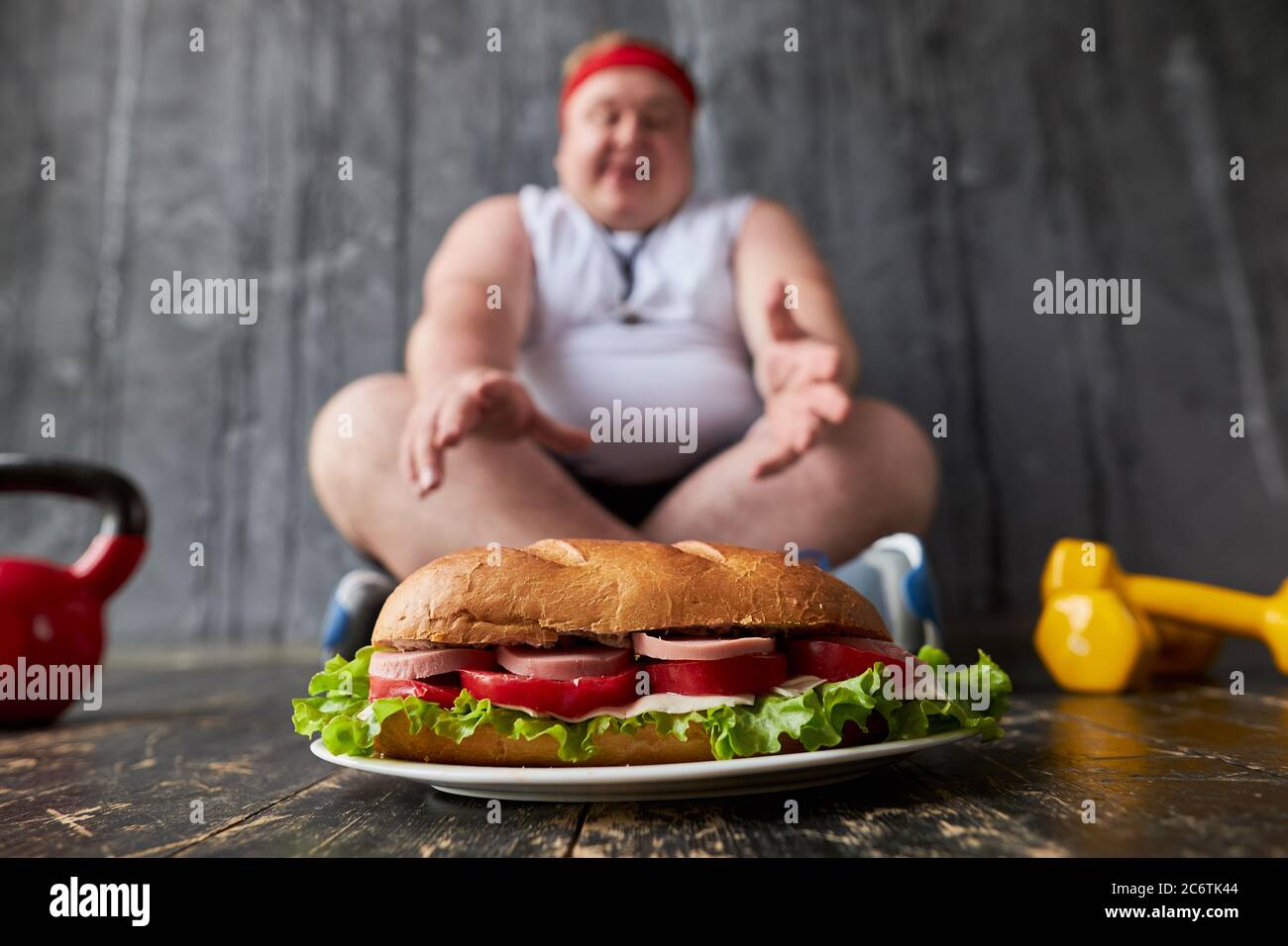 l'uomo caucasico in sovrappeso non può aderire a uno stile di vita sano e dieta, facendo esercizi sportivi e allo stesso tempo mangiare cibo malsano Foto Stock