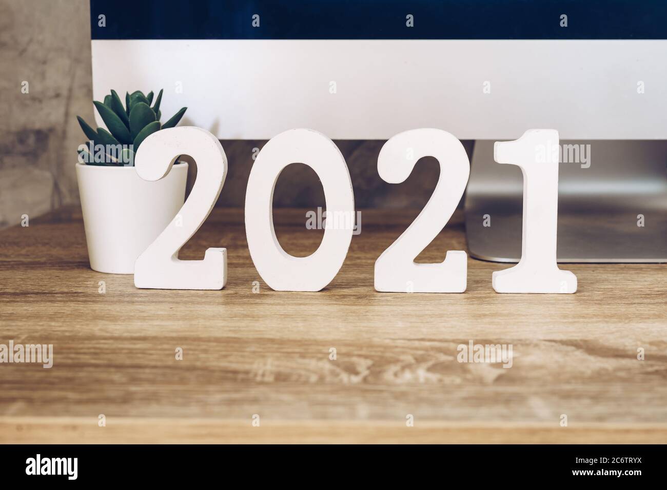 2021 felice anno nuovo su legno blocco su legno tavolo computer desktop e pentola pianta. nuovo anno concetto Foto Stock