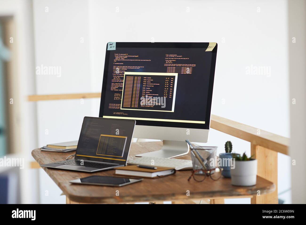 Immagine di sfondo del codice di programmazione in bianco e nero sullo schermo del computer e dei dispositivi digitali in interni moderni dell'ufficio, spazio di copia Foto Stock