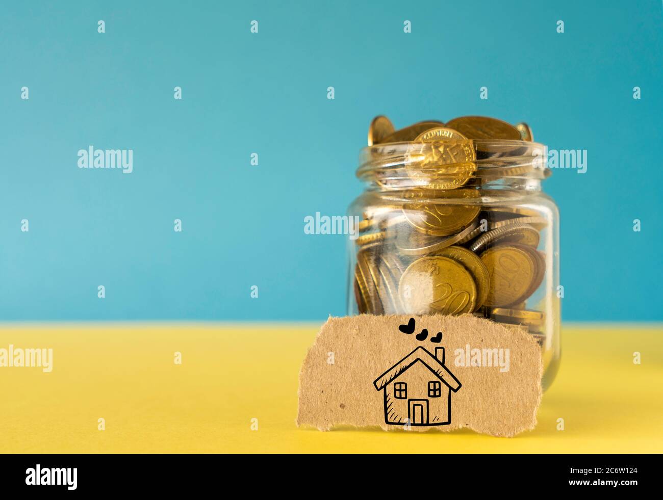 Un vasetto di moneta, risparmiando denaro per il concetto di casa Foto Stock