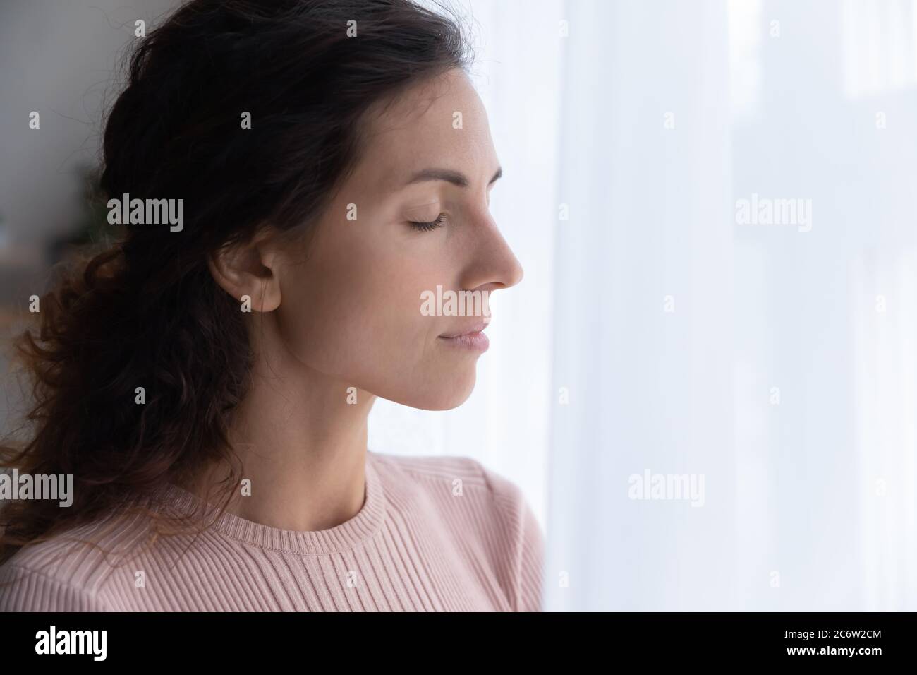 Calma giovane donna stare meditate con gli occhi chiusi Foto Stock