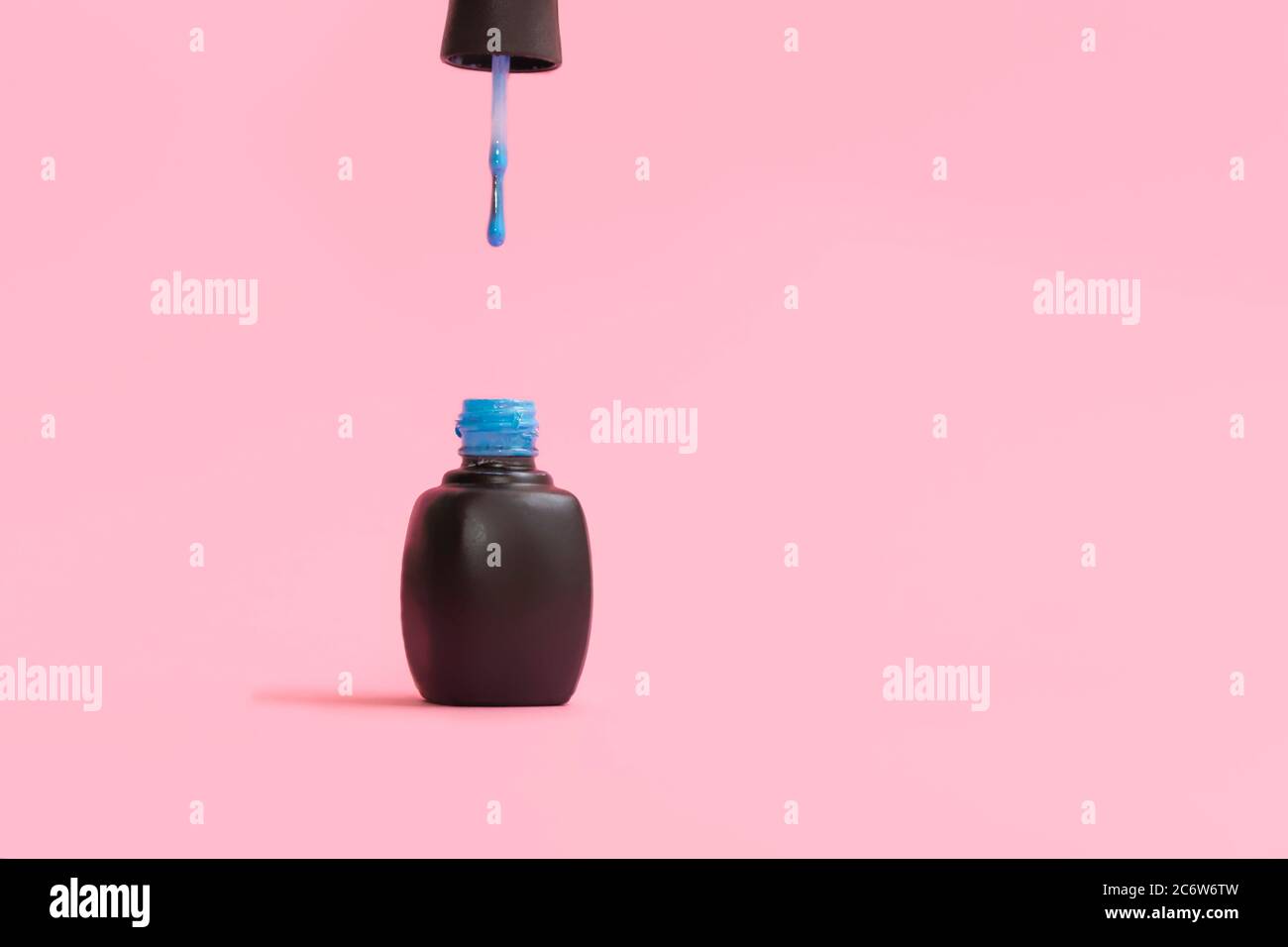 Aprire la bottiglia blu per smalto su sfondo rosa pastello con spazio per la copia Foto Stock