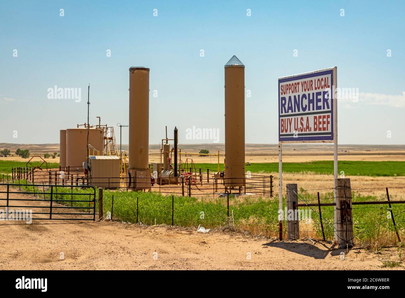 Kersey, Colorado - UN cartello accanto ai serbatoi di petrolio su un ranch del Colorado orientale chiede "Buy U.S.A. Beef". Questa zona di coltivazione e ranch ha visto oi esteso Foto Stock