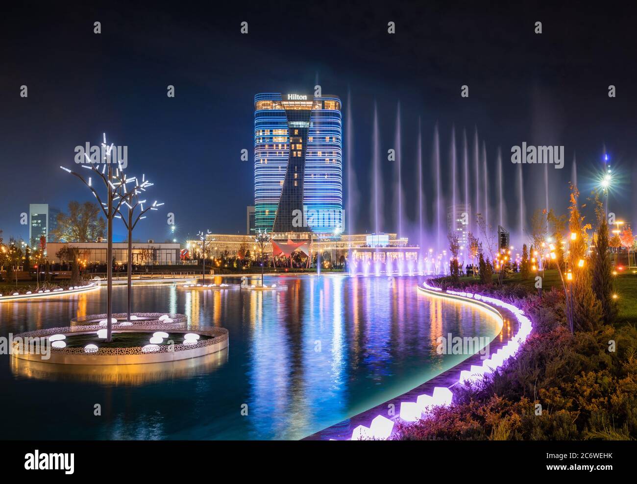 Tashkent, Uzbekistan - 30 Ottobre, 2019: bella fontana danzante illuminata di notte con la riflessione in Stagno nella nuova città di Tashkent Park Foto Stock