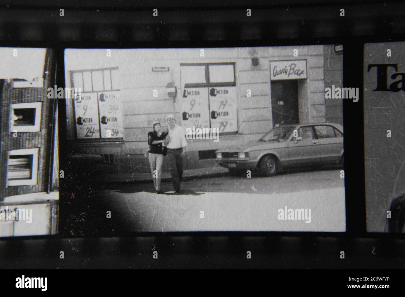 Bella fotografia di stile di vita in bianco e nero anni '70 di una coppia media che attraversa la strada. Foto Stock