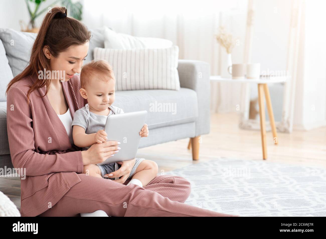 Dispositivi elettronici per bambini. Mamma e figlio del toddler che usano il tablet digitale a casa Foto Stock
