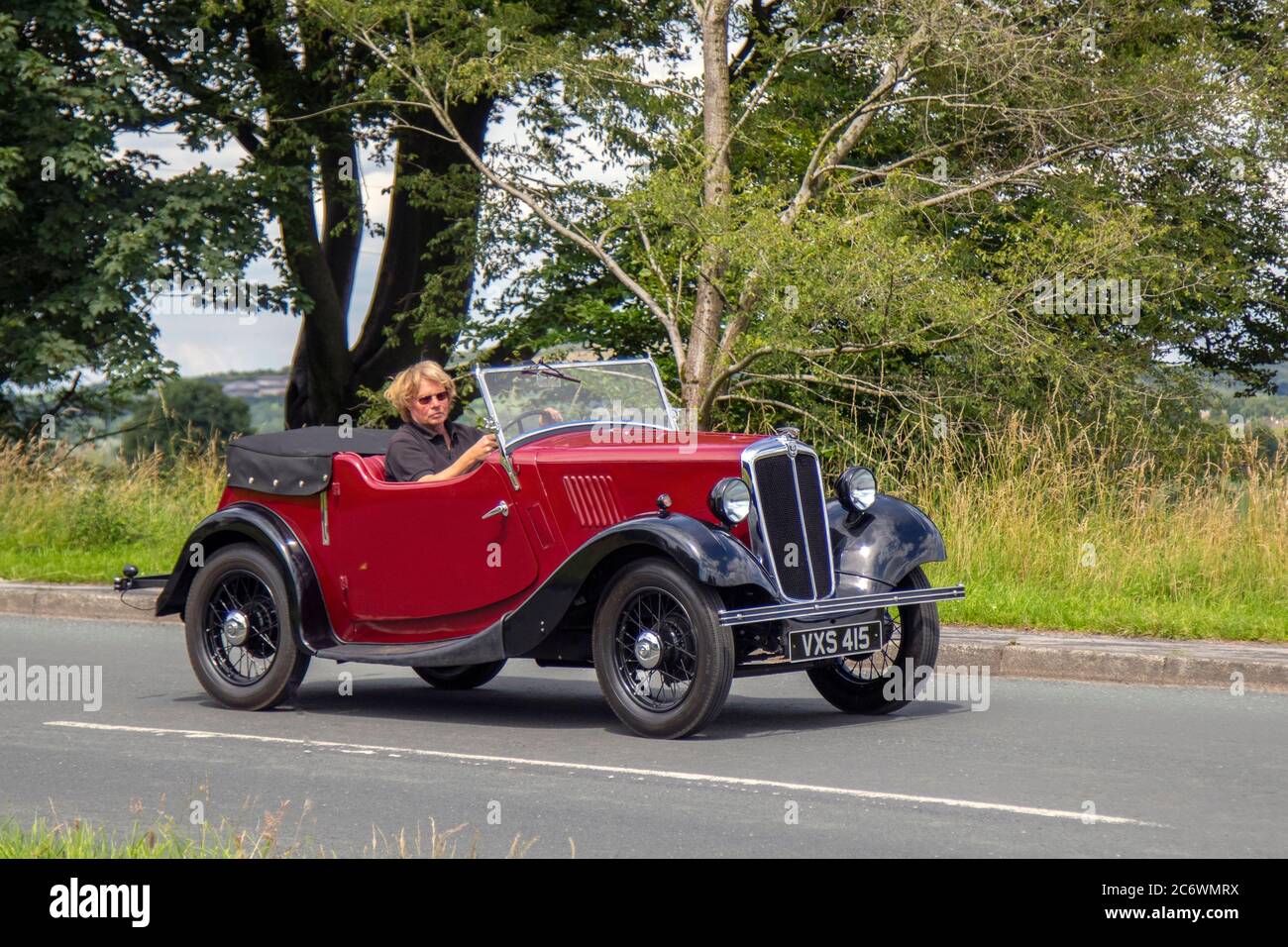 1936 pre-war 30s rosso Morris 8 decappottabile soft-top; veicoli in movimento per il traffico veicolare, 1930s auto che guidano veicoli su strade del Regno Unito, motori, automobilismo sulla rete autostradale M6. Foto Stock