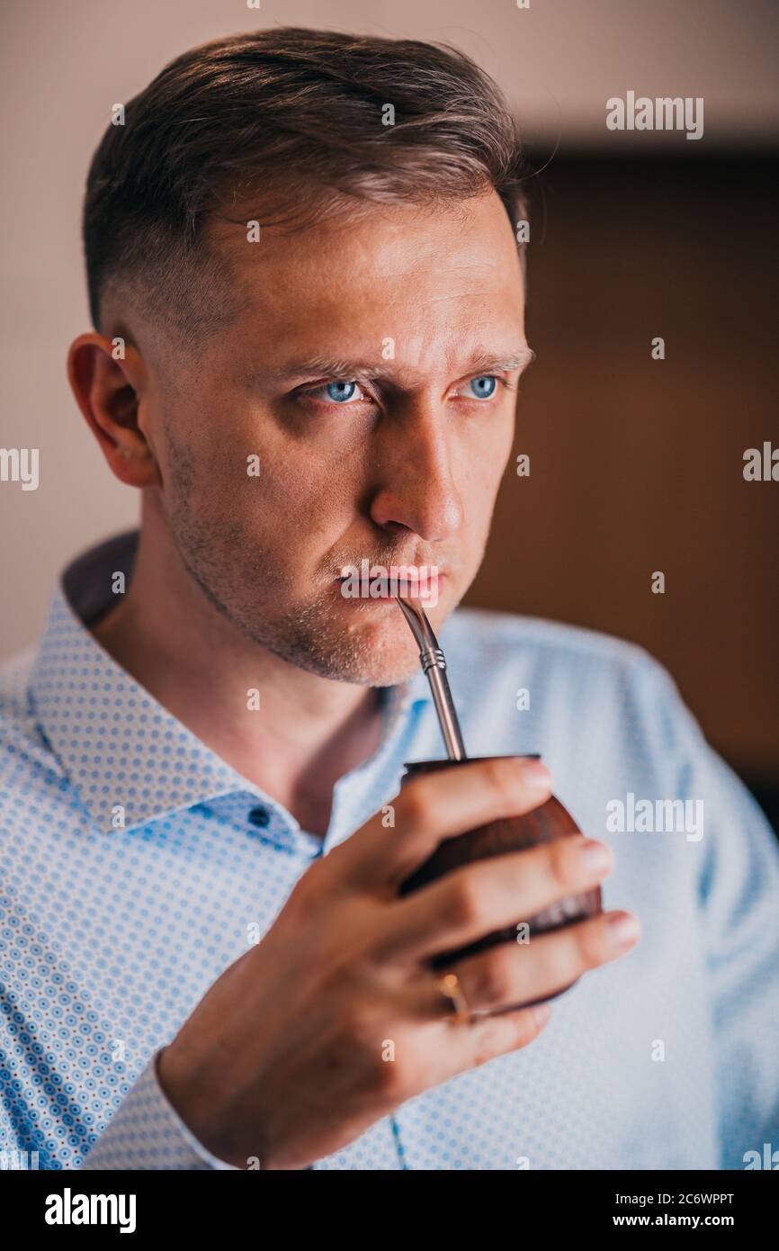 Uomo serio con uno sguardo poppa - occhi blu - bevande calabash mate Foto Stock