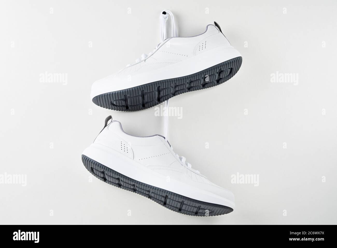 Paio di sneaker bianche da uomo appese alla parete. Scarpe sportive alla  moda, primo piano Foto stock - Alamy