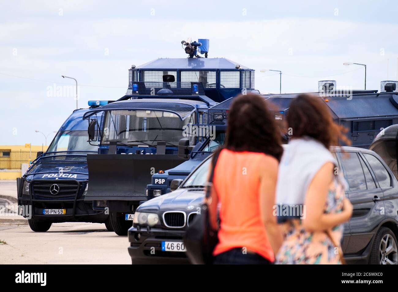 La polizia controlla i veicoli e 2 donne che li guardano a Lisbona, in Portogallo Foto Stock