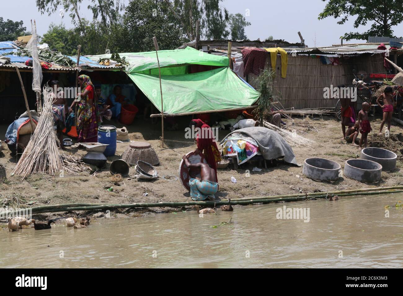 Le persone colpite dalle inondazioni si rifugiano su una diga durante l'alluvione monsonica a Gaibandha, nel nord del Bangladesh, il 19 luglio 2019. Ogni anno milioni di persone colpite da inondazioni a causa di forti piogge e fiumi in eccesso nelle parti nord-orientali e nord-occidentali del Bangladesh. Molte persone sono morte, sfollate, hanno perso le loro colture, le case, soffrono per gli alimenti e l'acqua potabile pura durante l'alluvione monsonica. Foto Stock