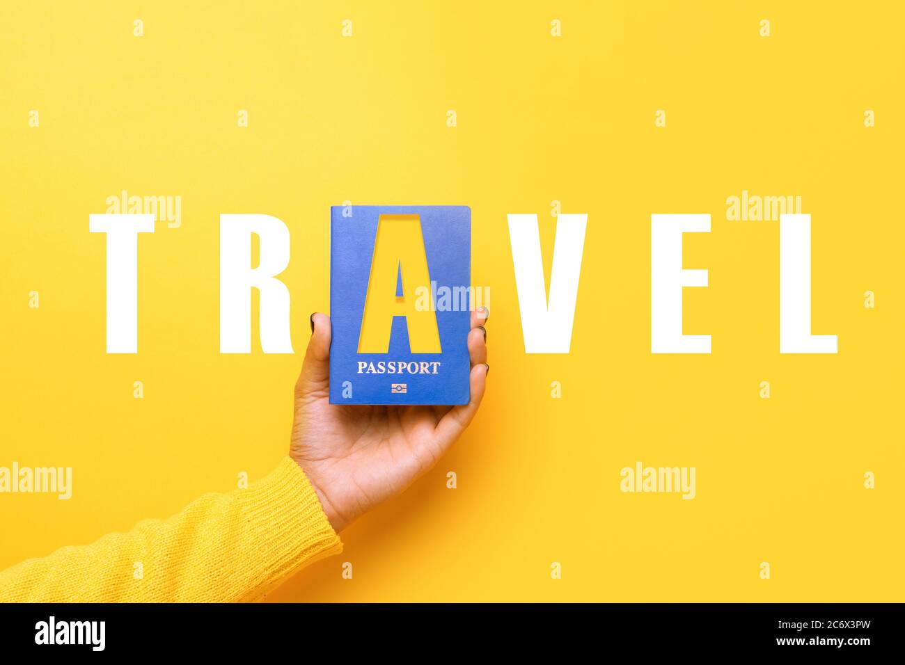 passaporto blu in mano su sfondo giallo, concetto di viaggio del mondo Foto Stock