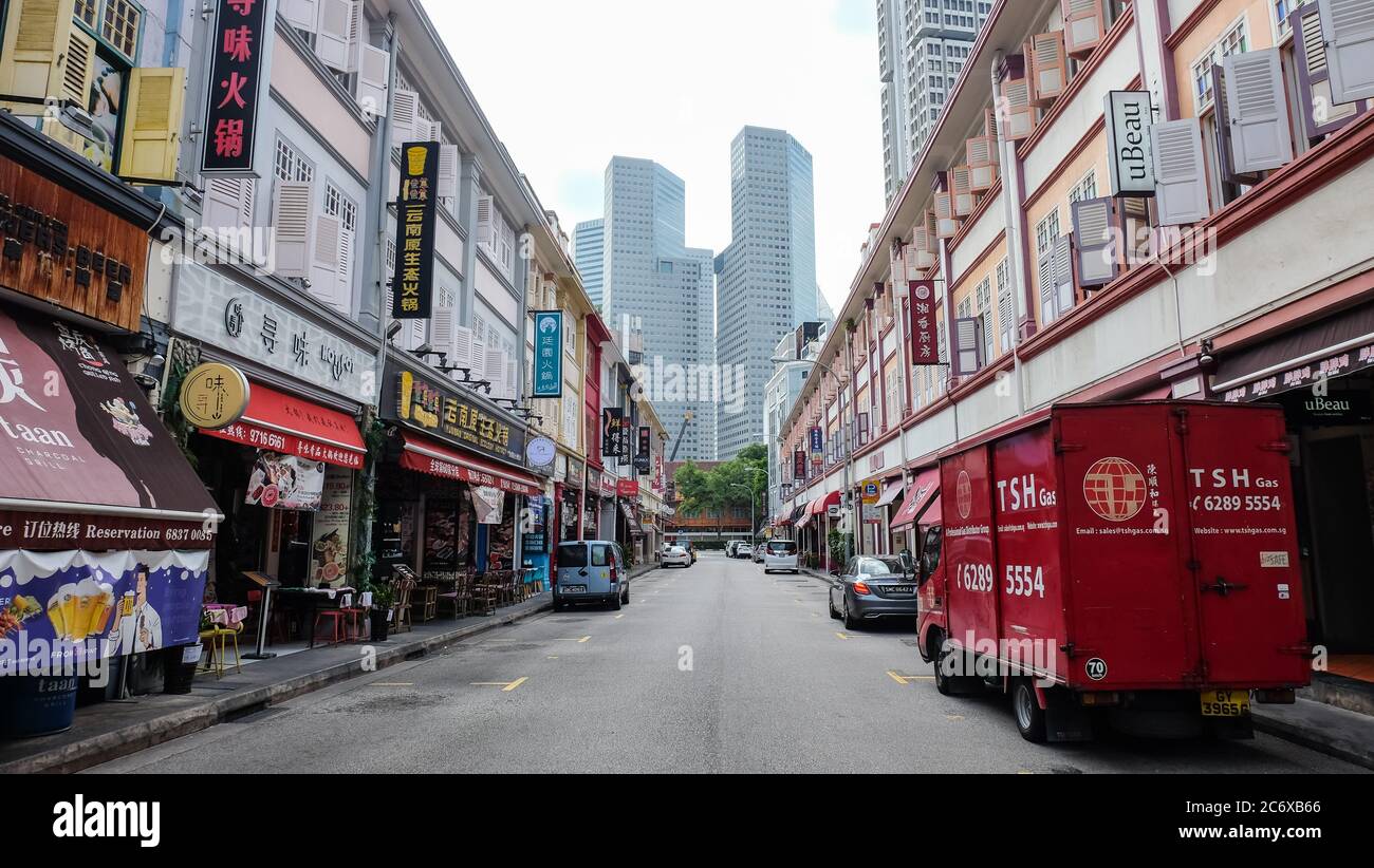 Il contrasto tra negozi e ristoranti in edifici tradizionali con l'architettura moderna di Suntec City sullo sfondo, Singapore Foto Stock