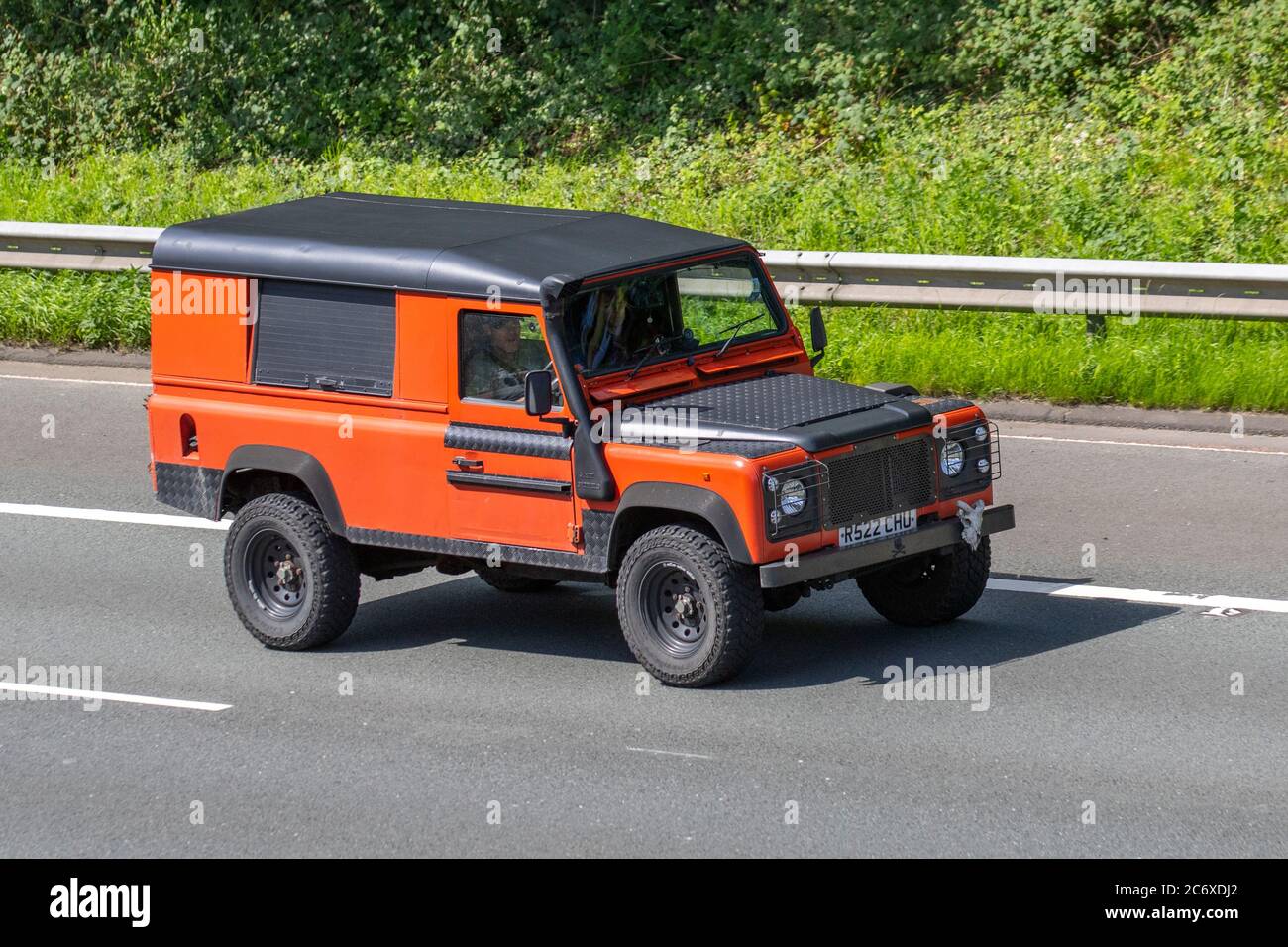 1997 90s, novanta nero arancione Land Rover 110 Defender TDI; veicoli in movimento per il traffico veicolare, auto che guidano veicoli su strade del Regno Unito, motori, automobilismo sulla rete autostradale M6. Foto Stock