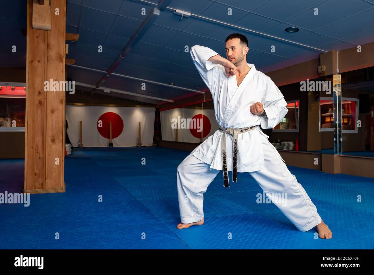 Karate man sta la tua terra su tatami facendo 'EMPI Wazaa' Foto Stock