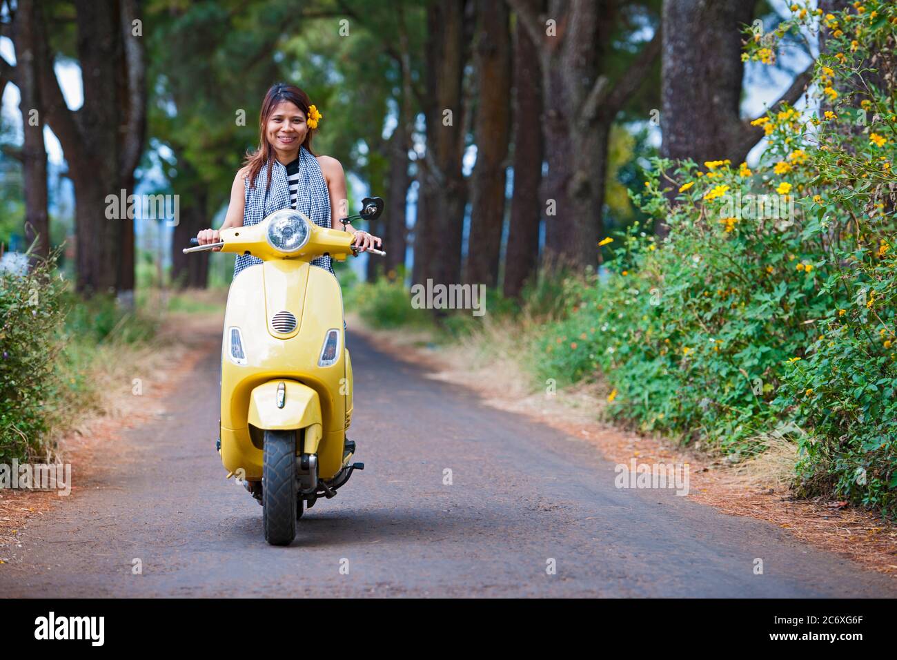 Donna vietnamita con scooter giallo in zona rurale in Vietnam Foto Stock