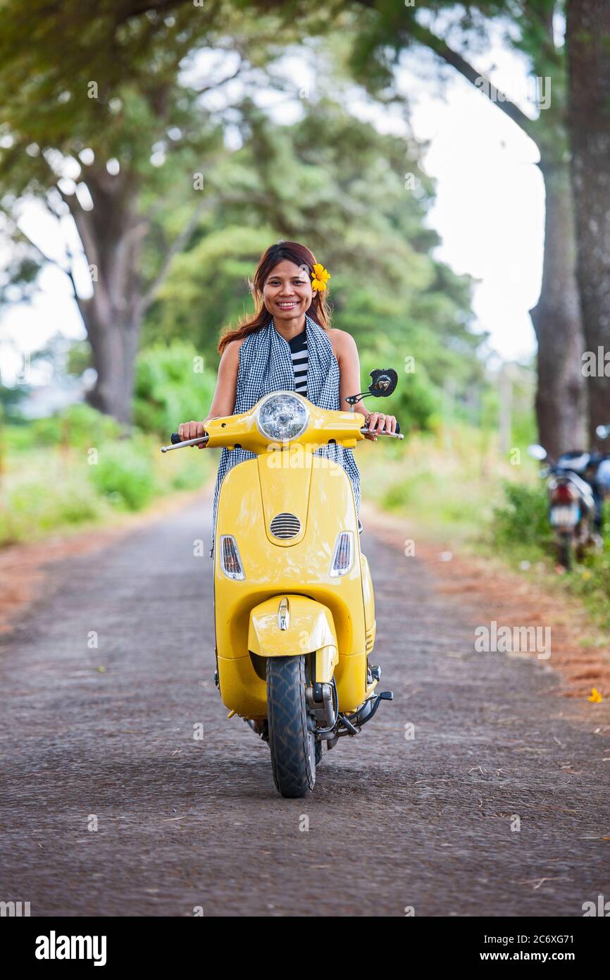 Donna vietnamita con scooter giallo in zona rurale in Vietnam Foto Stock