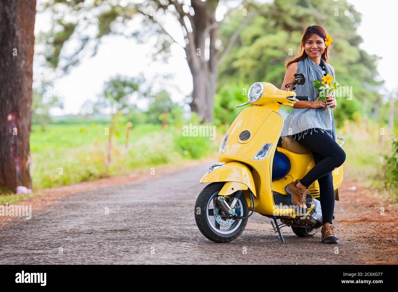 Donna vietnamita con scooter giallo in zona rurale in Vietnam Foto Stock