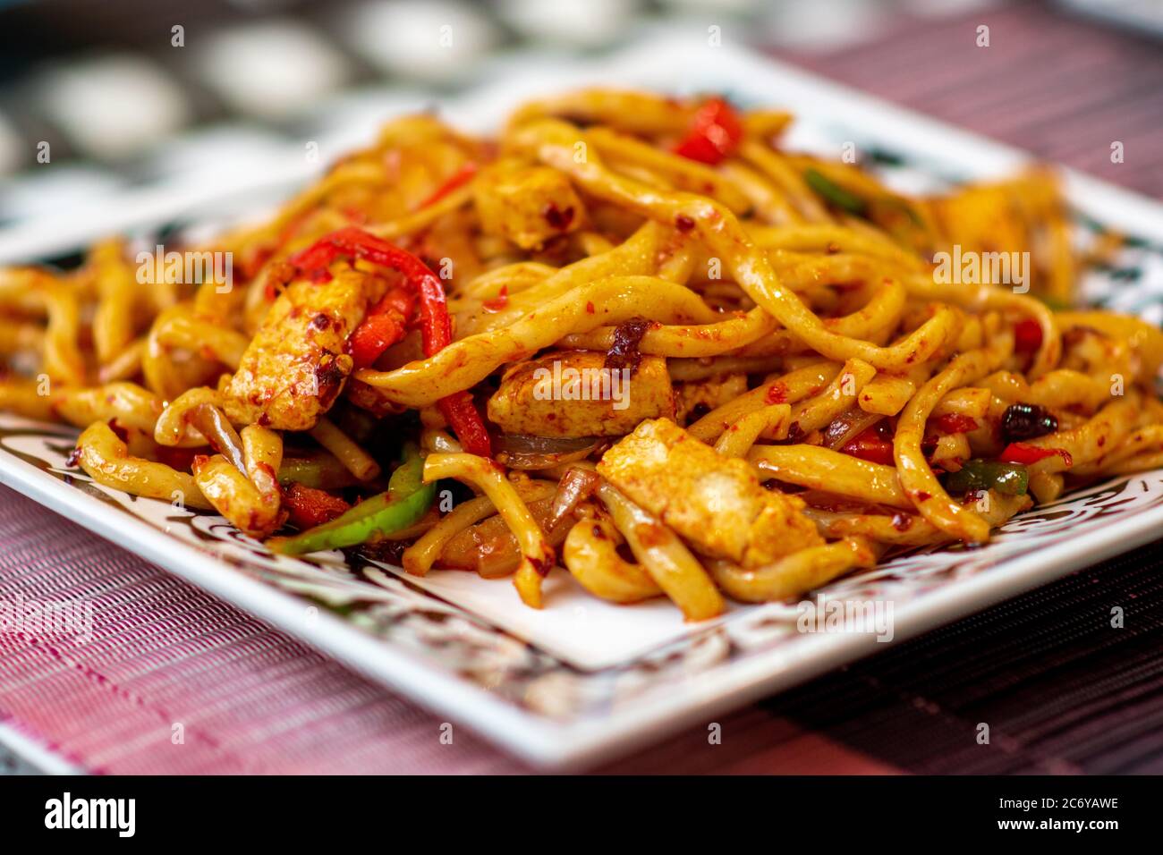 Tradizionale Uyghur dell'Asia centrale, piatto di noodle fritto in padella, Korma Chop. Spaghetti fritti con erba cipollina, tofu, cipolle e peperoni rossi. Foto Stock