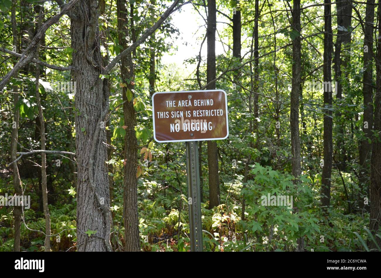 l'area dietro questo segno è limitata nessun segno di scavo con alberi in foresta o boschi Foto Stock