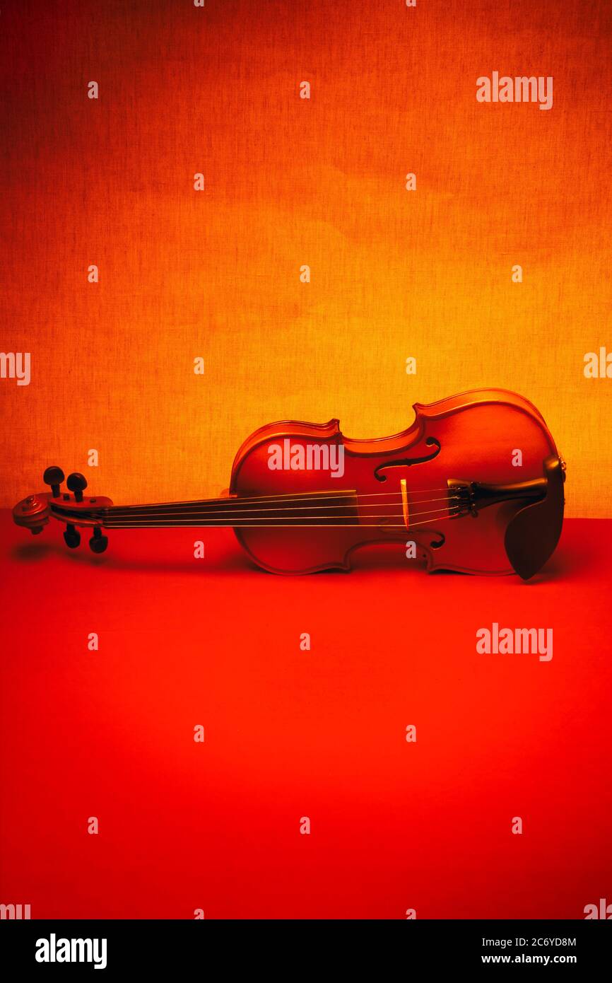 Ancora in vita con un violino su una tabella rossa. Minimalismo. Foto Stock