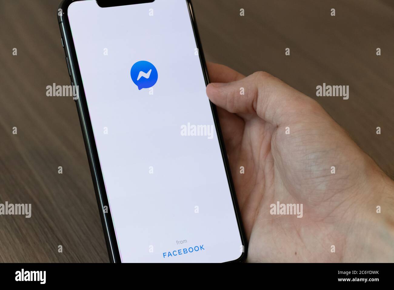 Persona che utilizza un cellulare con l'app Facebook Messenger sullo schermo. Foto Stock