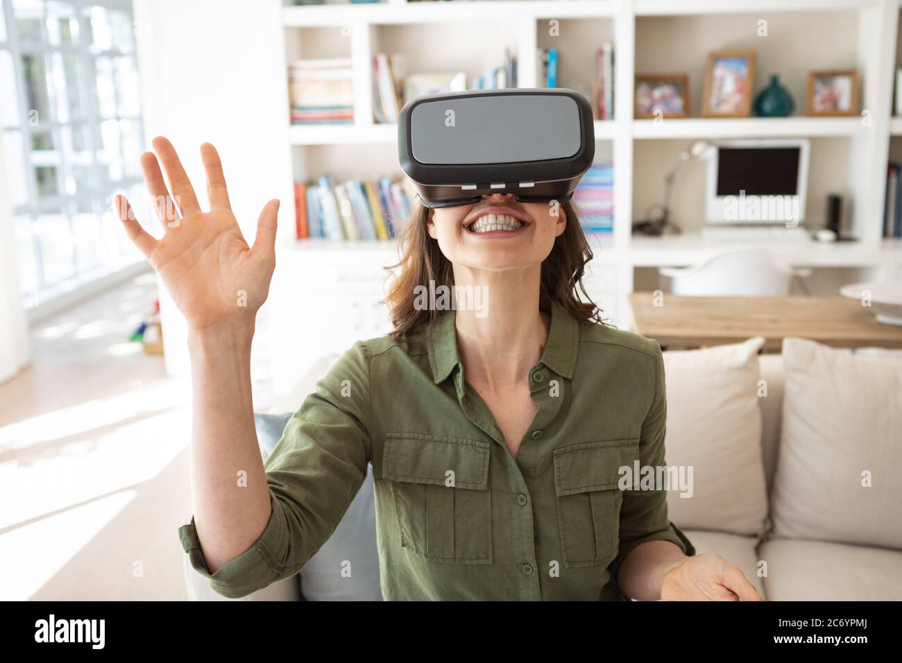 Donna che usa Virtual Reality Headset a casa Foto Stock