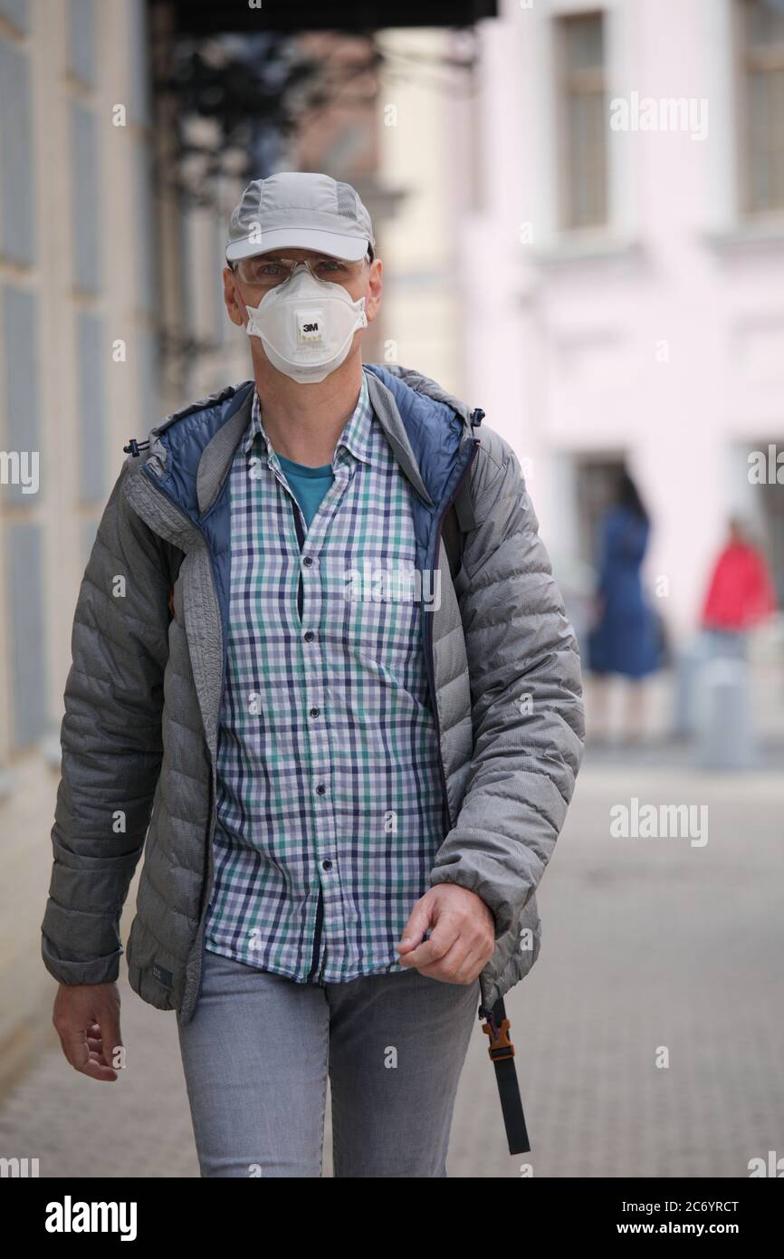 Uomo maturo con respiratore in città. Nuova normalità durante la pandemia COVID-19 Foto Stock